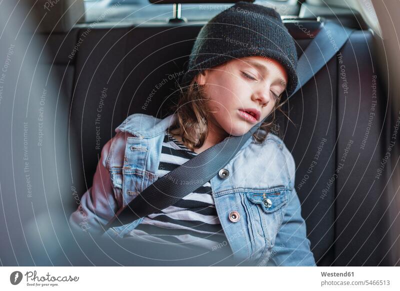 Portrait of sleeping little girl on back seat of a car cap hats caps copy space woolly hat Wooly Hat Knit-Hat Knit Hats wool cap denim jacket jeans jackets