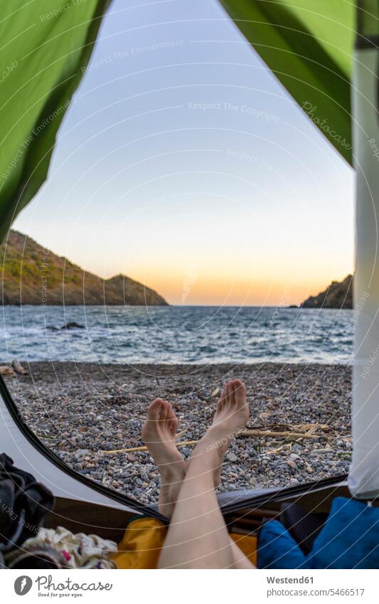 Spain, Catalonia, Costa Brava, woman lying barefoot in tent camping beach beaches tents alone solitary solo leg legs human leg human legs laying down lie