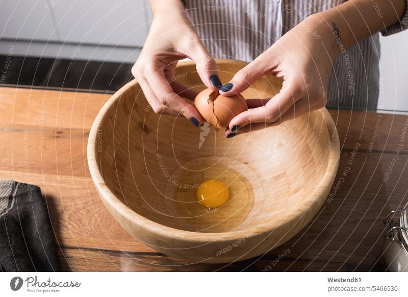 Woman breaking egg, wooden bowl Mixing Bowl hand human hand hands human hands baking bake eggshell Egg Shells eggshells preparation prepare preparing egg yolk