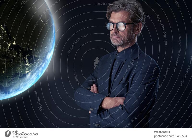 Portrait of mature businessman against dark background watching floating planet earth business life business world business person businesspeople Business man