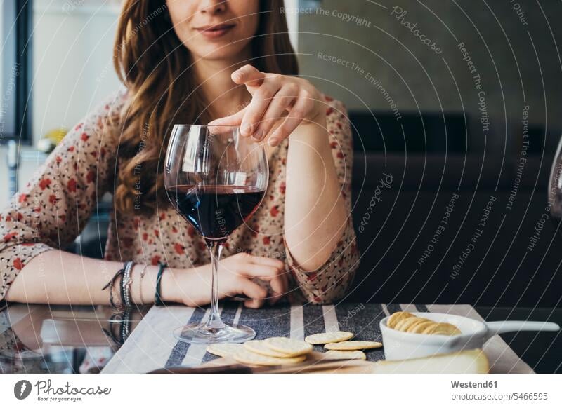 Young woman touching wineglass while sitting at dining table color image colour image indoors indoor shot indoor shots interior interior view Interiors