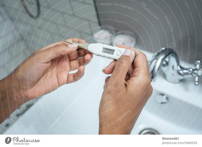 Close-up of woman holding thermometer in bathroom basin basins at home sick health healthcare Healthcare And Medicines medical medicine disease diseases ill