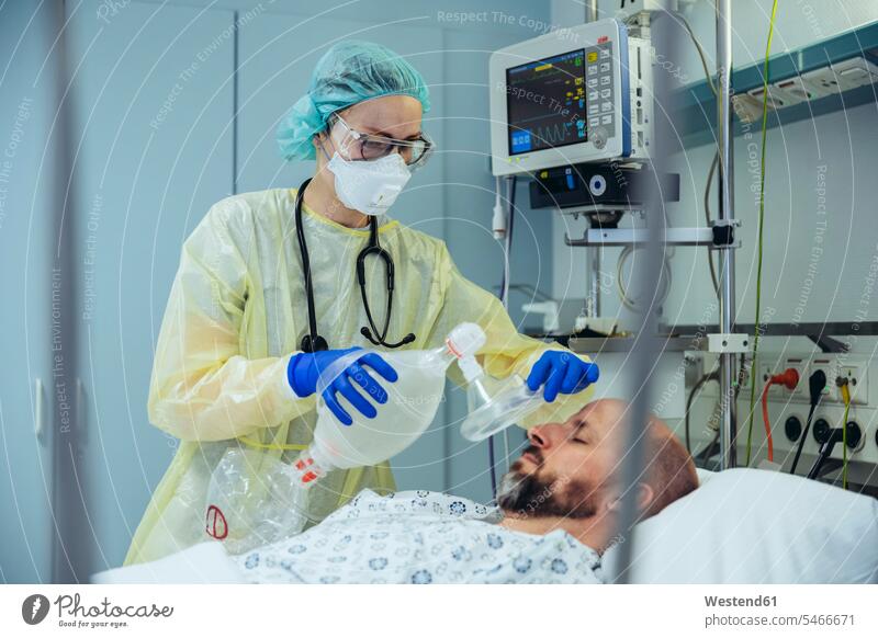 Doctor with bag valve mask caring for patient in emergency care unit of a hospital human human being human beings humans person persons caucasian appearance