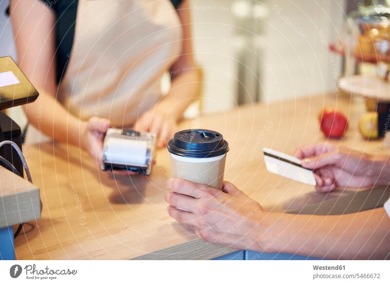 Close-up of customer paying by credit card in a cafe clientele clients customers debit card people persons human being humans human beings cashless finances