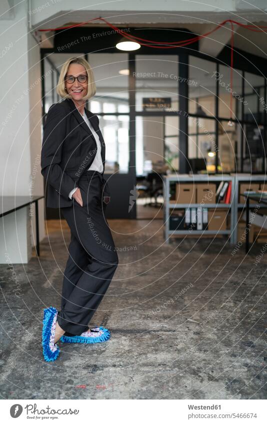 Portrait of smiling mature businesswoman wearing cleansing slippers in office human human being human beings humans person persons caucasian appearance