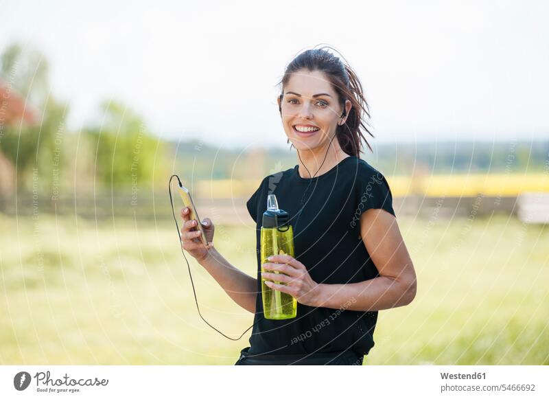 Sportive woman using smartphone during cooling break Listening Music smiling smile on the phone call telephoning On The Telephone calling earphones ear phone
