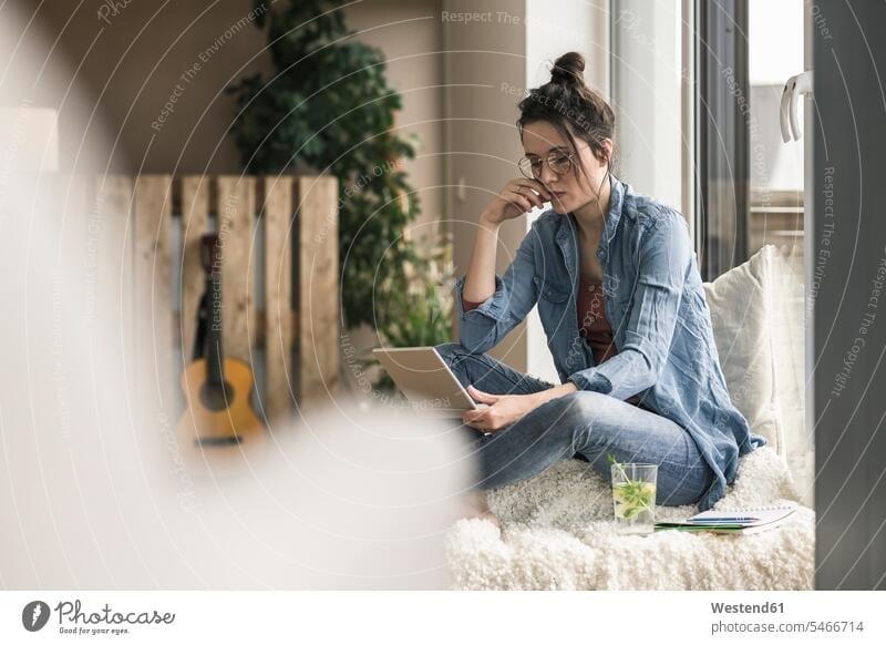 Woman sitting at the window at home using laptop woman females women Laptop Computers laptops notebook Seated windows Adults grown-ups grownups adult people