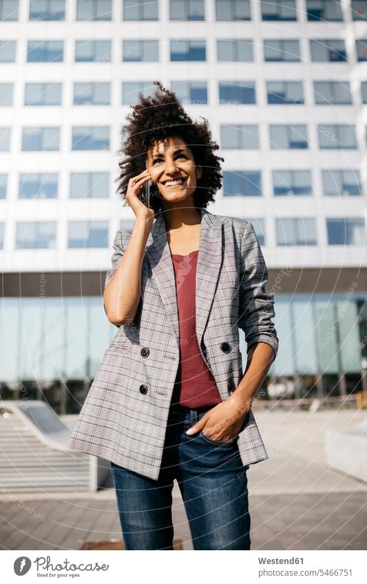 Smiling businesswoman on cell phone outside office building on the phone call telephoning On The Telephone calling businesswomen business woman business women