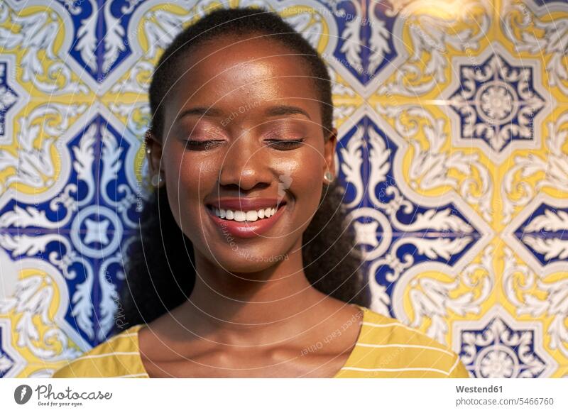 Portrait of a happy young woman at a tiled wall African descent black coloured front view frontal View From Front Frontal View front views head on head-on