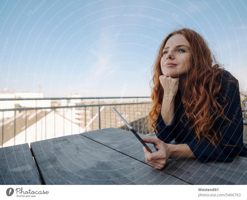 Redheaded woman with tablet on rooftop terrace business life business world business person businesspeople business woman business women businesswomen Tables