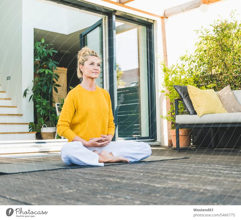 Portrait of mature woman meditating on terrace jumper sweater Sweaters relax relaxing Seated sit colour colours at home free time leisure time Lifestyle