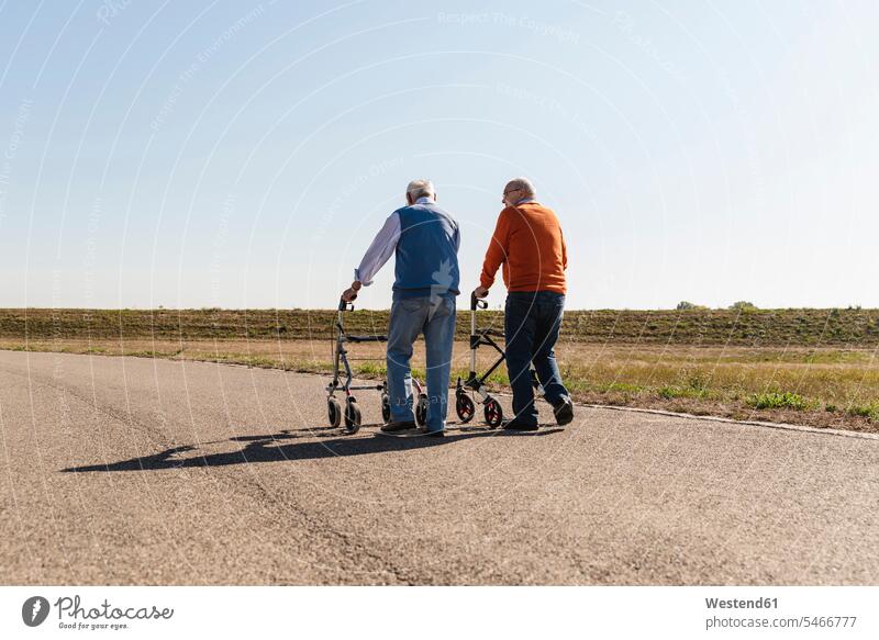 Two old friends walking on a country road, using wheeled walkers caucasian caucasian ethnicity caucasian appearance european Best Friend Best Friends Best Pal