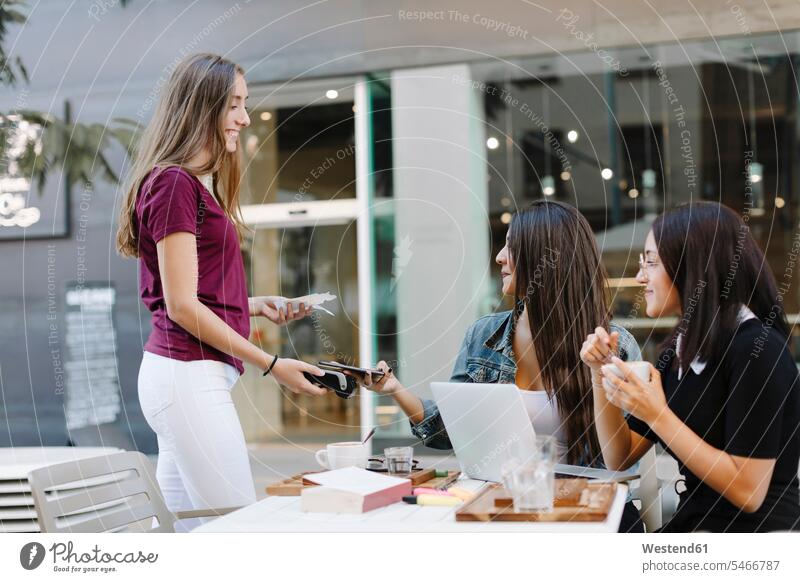 Young woman paying cashless with smartphone in a cafe Spain card reader Cardkey Reader chip and pin machine noncash wireless Wireless Connection