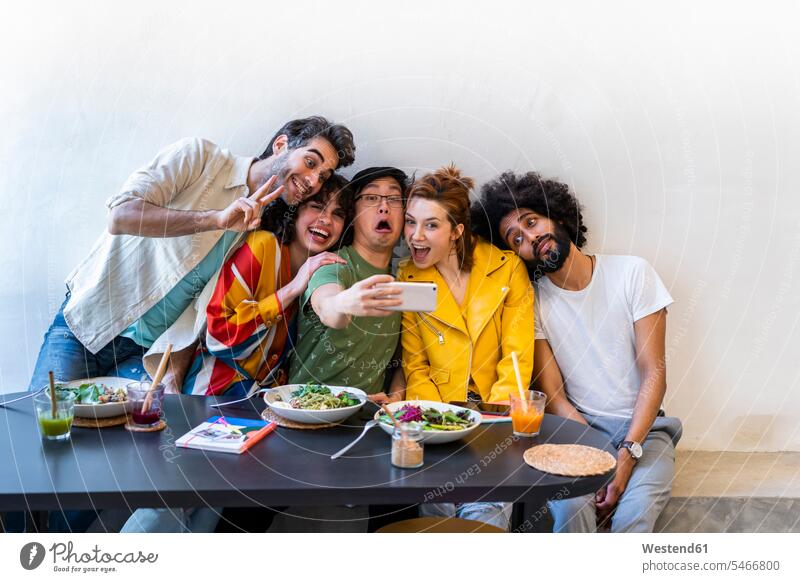 Group of friends having lunch in a restaurant taking a selfie Drinking Glass Drinking Glasses dish dishes Plates images picture pictures photo photographs