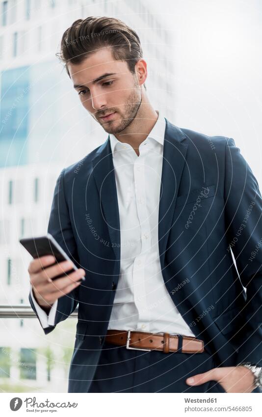 Businessman at the window using cell phone Business man Businessmen Business men mobile phone mobiles mobile phones Cellphone cell phones smiling smile windows