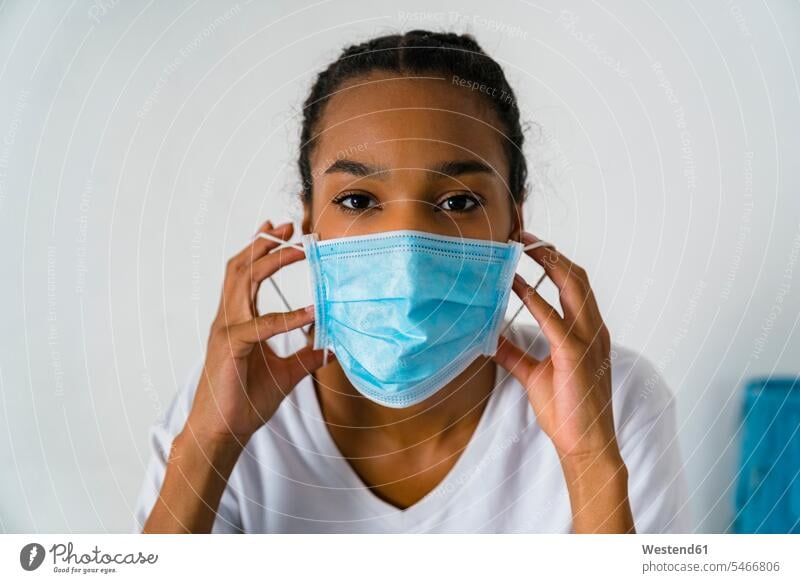 Young girl wearing protective face mask standing against wall color image colour image indoors indoor shot indoor shots interior interior view Interiors day