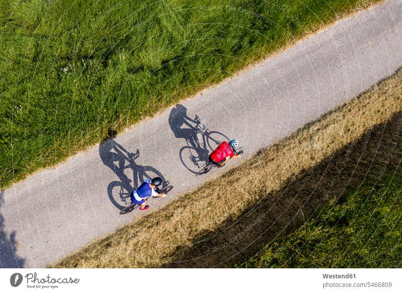 Triathletes riding bicycle on country road, Germany human human being human beings humans person persons caucasian appearance caucasian ethnicity european 2