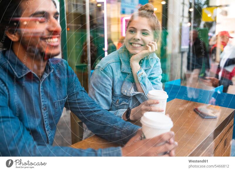 Portrait of smiling young woman in a coffee shop looking at young man windows pane panes window glass window glasses Window Pane windowpanes flirt Flirtation