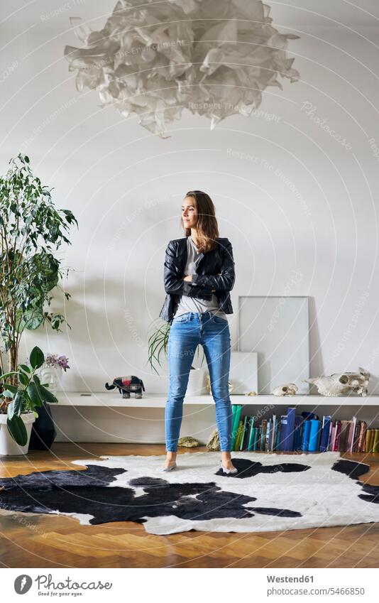Confident young woman standing on fur in a room Self-confidence self-confident poised Self-Assured Self-Assurance rooms domestic room domestic rooms furs hide