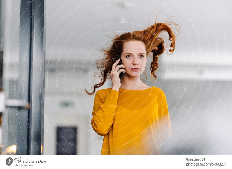 Woman with windswept hair on the phone in office Occupation Work job jobs profession professional occupation business life business world business person