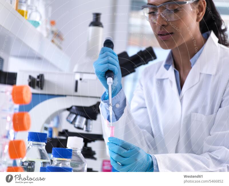 Genetic research, female scientist pipetting DNA or chemical sample into a eppendorf vial, analysis in the laboratory pipette dropper pipets pipettes ampulla