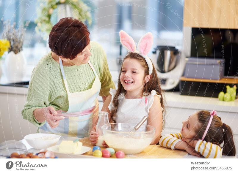 Grandmother and granddaughters baking Easter cookies in kitchen together bake grandmother grandmas grandmothers granny grannies Biscuit Cookie Cooky Cookies