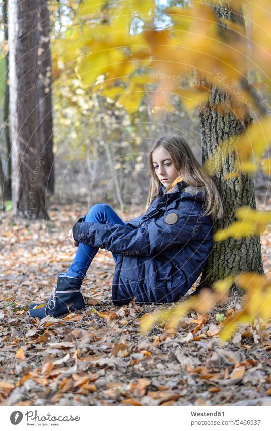 Portrait of unhappy girl in autumnal forest woods forests dissatisfied displeased unlucky autumnally portrait portraits females girls fall child children kid