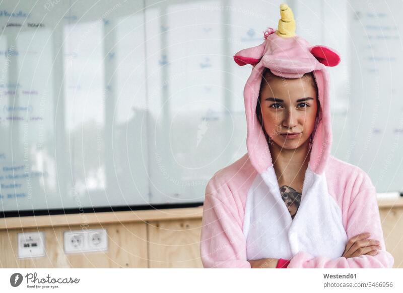 Woman wearing unicorn onesie, standing in front of whiteboard, looking stubborn office offices office room office rooms Onesie headstrong white board obstinate