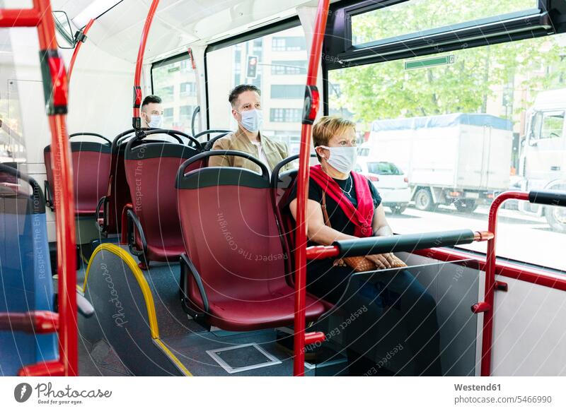 Passengers wearing protective masks in public bus, Spain transport motor vehicles road vehicle road vehicles buses busses travel traveling Seated sit mobile