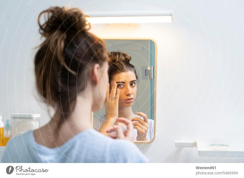Rear view of young woman in bath room mirrors in the morning at home Everyday Everyday Scene Everyday Scenes Routine Beauty Care Beauty Culture Attractiveness