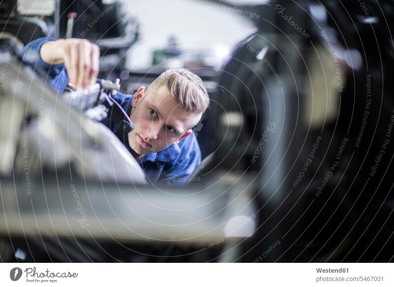 Young man adjusting a machine in a printing company human human being human beings humans person persons caucasian appearance caucasian ethnicity european 1