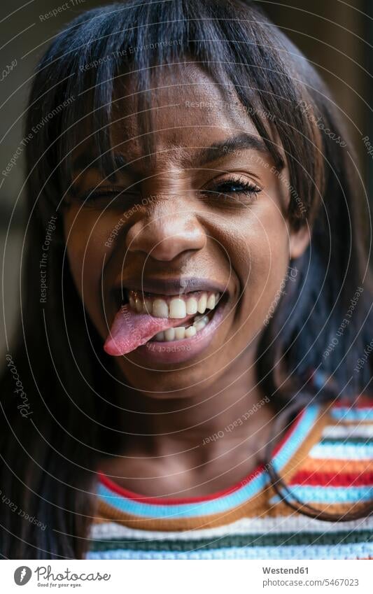 Portrait of laughing young woman sticking out tongue tongues portrait portraits females women Laughter mouth mouths people persons human being humans