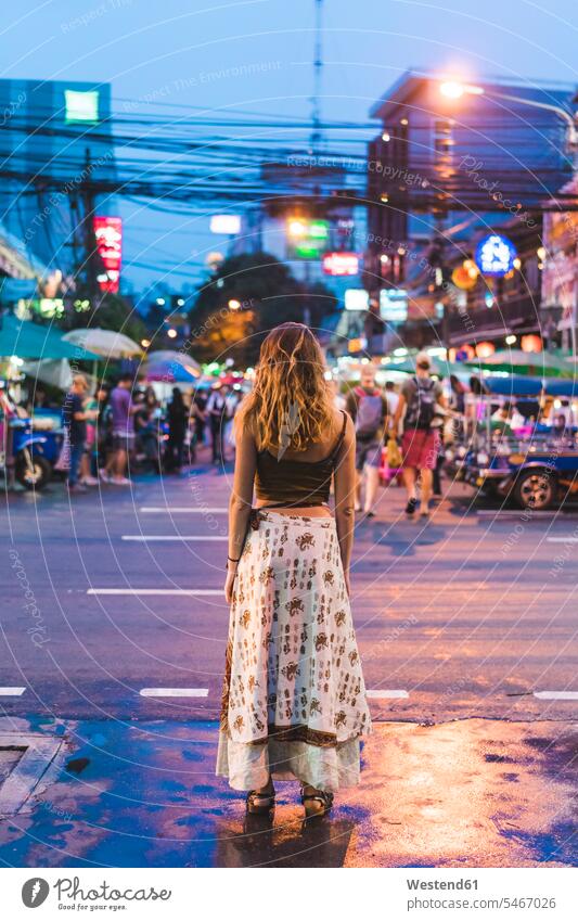 Thailand, Bangkok, young woman in the city standing on the street at night females women by night nite night photography town cities towns road streets roads