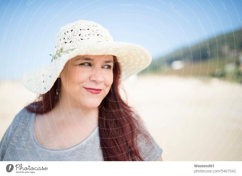 Portrait of smiling woman wearing summer hat on the beach hats summer hats portrait portraits beaches females women smile Adults grown-ups grownups adult people