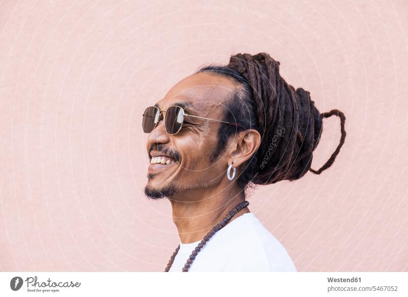 Portrait of smiling mature man with dreadlocks and sunglasses T- Shirt t-shirts tee-shirt necklaces Eye Glasses Eyeglasses specs spectacles Pair Of Sunglasses