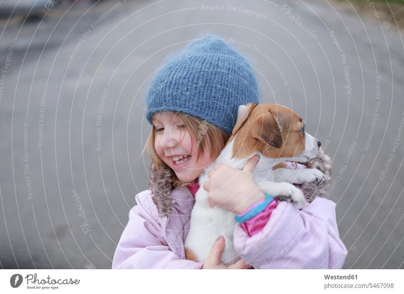 Happy little girl holding Jack Russel Terrier puppy dog dogs Canine pups puppies happiness happy females girls pets animal creatures animals young animal