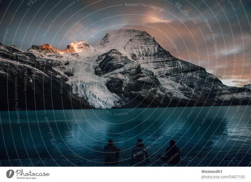 Canada, British Columbia, Mount Robson Provincial Park, hikers resting at Berg Lake at dusk sitting Seated lake lakes wanderers View Vista Look-Out outlook man
