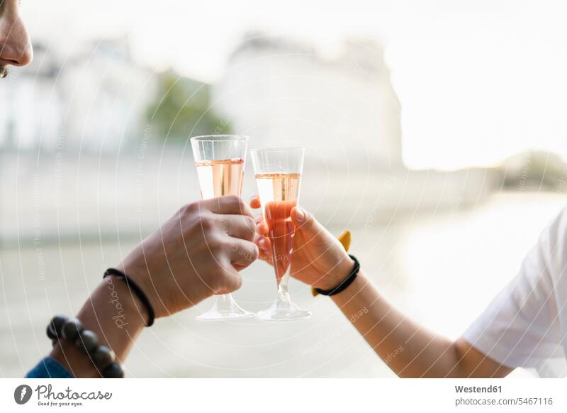 Close-up of couple clinking champagne glasses at the riverside riverbank Champagne Flute Champagne Flutes Champagne Glass toasting cheers Sparkling Wine