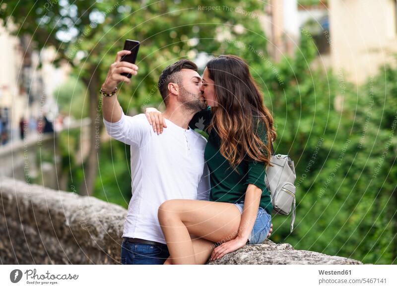 Couple in love in the city kissing and taking a selfie Affection Affectionate alley lane Laneway Selfie Selfies kisses Love loving couple twosomes partnership