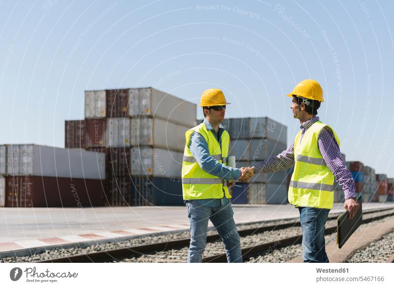 Workers shaking hands on railway tracks near cargo containers on industrial site Spain expertise expert knowledge know-how analytic expertise know how documents