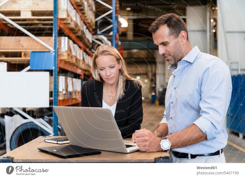 Female and male entrepreneurs concentrating while working on laptop color image colour image indoors indoor shot indoor shots interior interior view Interiors