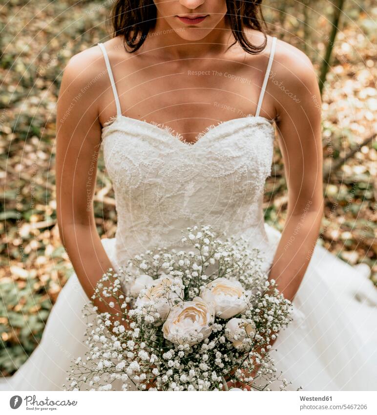 Close-up of bride holding bouquet of flowers in forest brides Wedding getting married marrying Marriage standing woman females women Bunch of Flowers Bouquet
