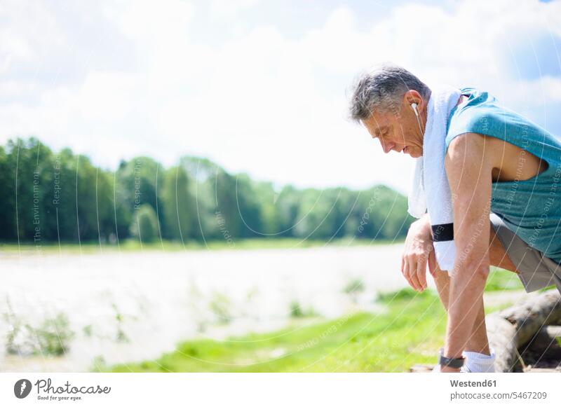 Side view of exhausted retired man at riverbank on sunny day color image colour image outdoors location shots outdoor shot outdoor shots daylight shot