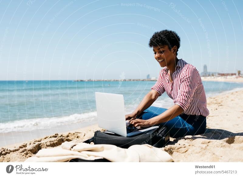 Woman sitting on the beach while working with the laptop human human being human beings humans person persons Mixed Race mixed race ethnicity mixed-race Person