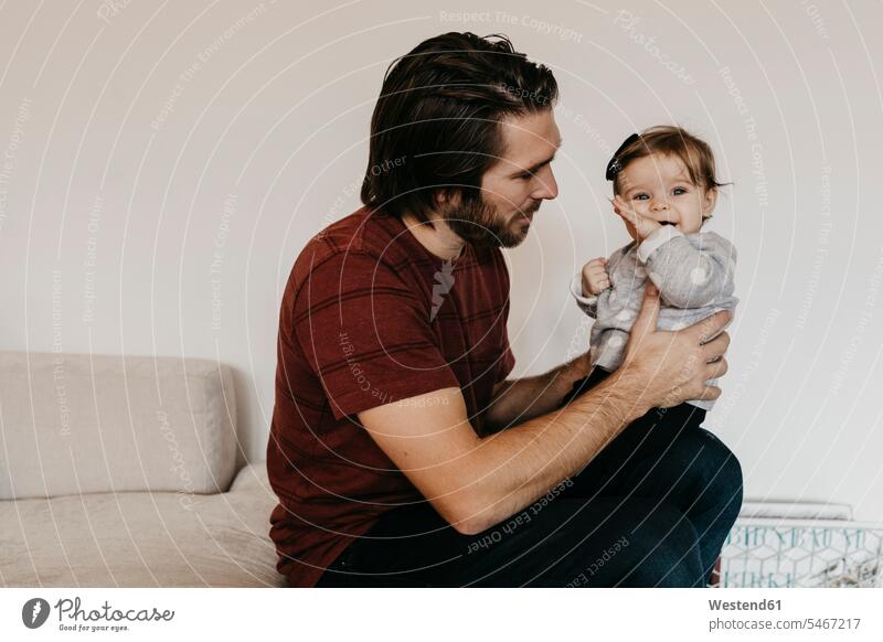 Father holding baby girl at home family families infants nurselings babies father pa fathers daddy dads papa people persons human being humans human beings