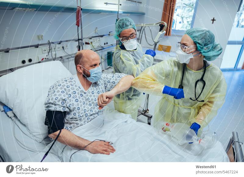 Doctors making elbow bump with cured patient in emergency care unit of a hospital colleague health healthcare Healthcare And Medicines medical medicine disease