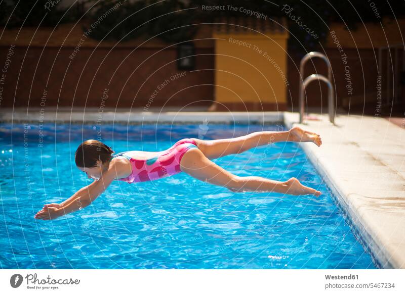 Young girl jumping head first into the pool in summer females girls water headfirst Leaping header jackknifing diving cooling Cool Down cooling down child