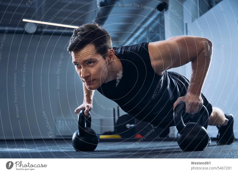 Man doing pushups on kettlebells at gym workout working out work out gyms Health Club exercise exercises Push-up Push-ups press-up press-ups Push Up Push Ups