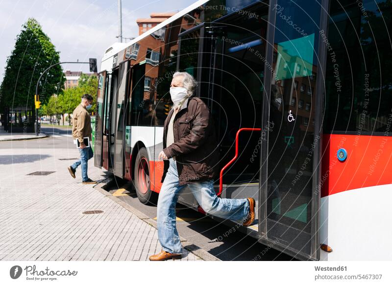 Senior man wearing protective mask getting off public bus, Spain human human being human beings humans person persons caucasian appearance caucasian ethnicity