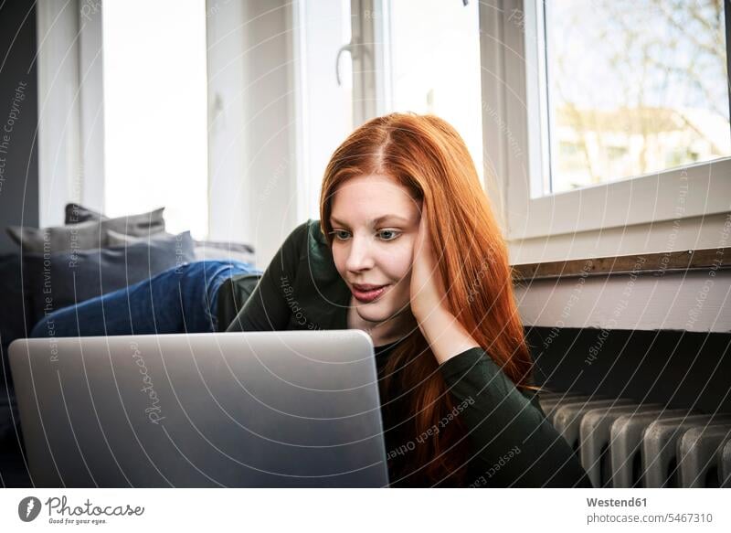 Portrait of redheaded woman using laptop at home females women Laptop Computers laptops notebook use red hair red hairs red-haired Adults grown-ups grownups